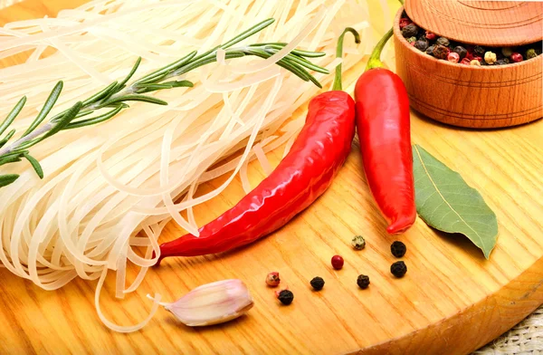 Rå risnudlar med chili peppar, kvist rosmarin, lagerblad, gar — Stockfoto