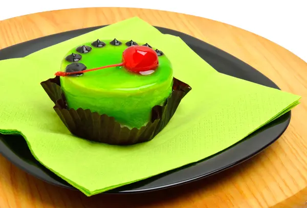 Heerlijke groene cake met kers op zwarte plaat op snijden backg — Stockfoto