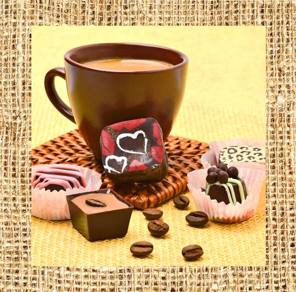 Kopp cappuccino med choklad godis och kaffebönor — Stockfoto