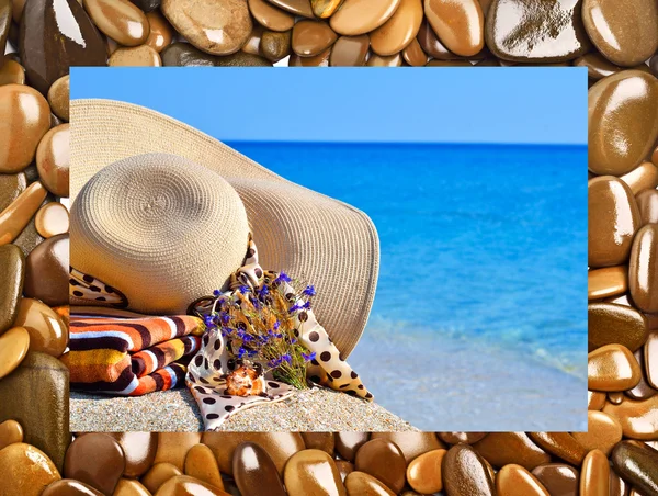 Woman beach hat, bright towel and flowers against blue ocean — Stock Photo, Image