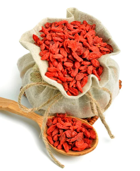 Goji berries in the sack bag with wooden spoon isolated — Stock Photo, Image