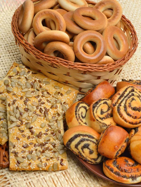 Rotoli al forno con semi di papavero su un piatto, bagel e biscotti Fotografia Stock