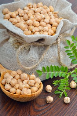 Nohut ahşap arka plan üzerinde bir çuval bezi çanta