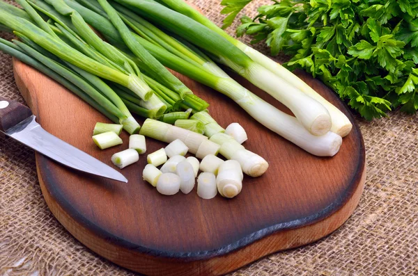 Gehackte grüne Zwiebeln mit Petersilie und Messer — Stockfoto