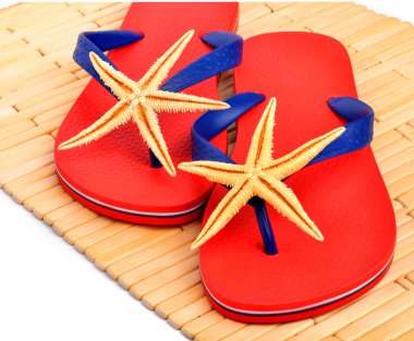 Kırmızı parmak arası terlik, terlik ile denizyıldızı ahşap arka plan üzerinde 