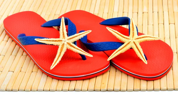 Chanclas rojas, zapatillas con estrellas de mar en el fondo de madera —  Fotos de Stock