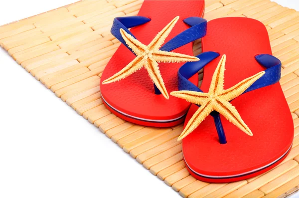 Chanclas rojas, zapatillas con estrellas de mar en el fondo de madera — Foto de Stock