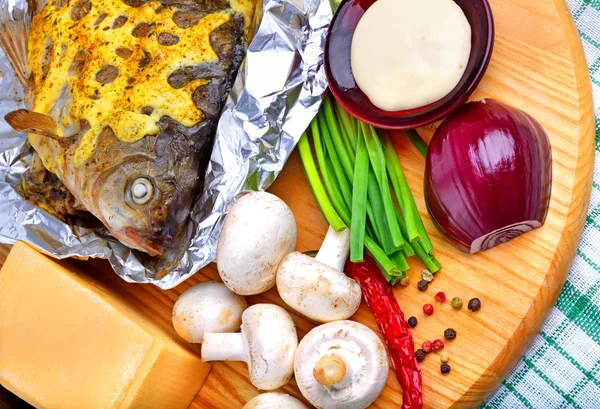 Gebakken vis met groenten, saus, rode peper op snijplank — Stockfoto