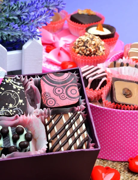 Assortment of chocolate sweets in gift boxes, lavender — Stock Photo, Image