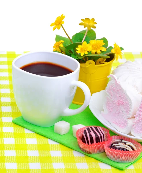 Šálek kávy s murshmellow, čokoládové sladkosti, žluté květy je další — Stock fotografie
