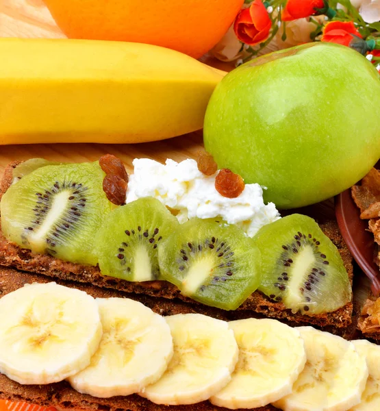 Gesunde Ernährung. frisches Obst und trockene Brote mit Quark auf einem hölzernen — Stockfoto