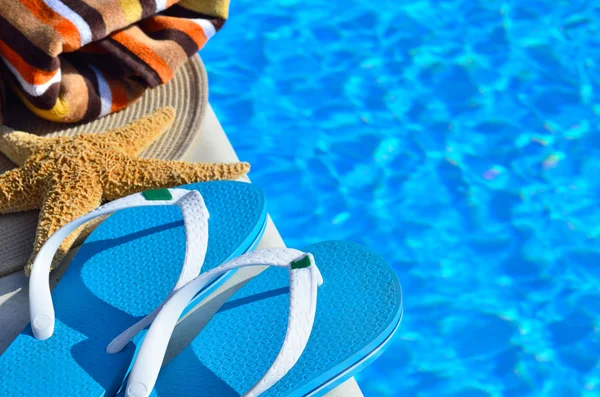 Sombrero de playa de mujer, toalla brillante y chanclas azules —  Fotos de Stock