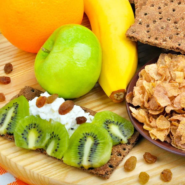 Zdravé stravování. Čerstvé ovoce, kukuřičných lupínků a suchý chleba s tvarohem Stock Fotografie