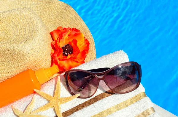 Cappello da spiaggia, occhiali da sole, telo da bagno, spray solare, stelle marine vicino — Foto Stock
