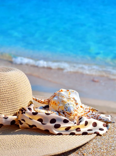 Vrouw strand hoed, heldere handdoek tegen blauwe oceaan — Stockfoto