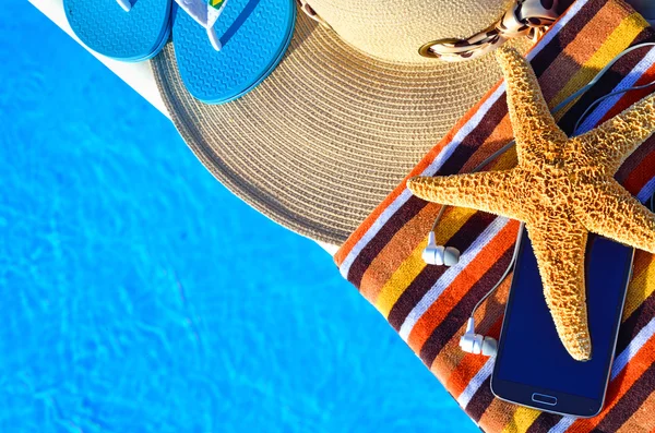 Beach hat, bath towels, cell phone, starfish, thongs near the sw — Stock Photo, Image