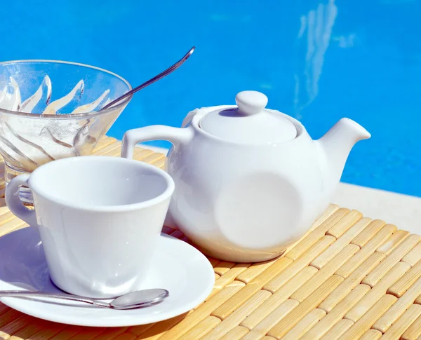 Filiżanka herbaty na talerzyk i czajnik — Zdjęcie stockowe