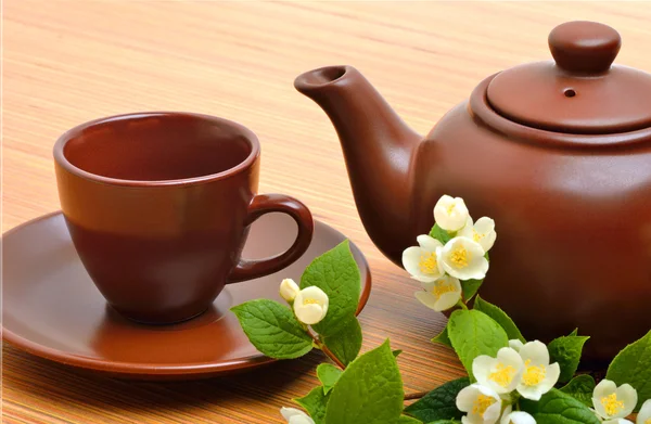 Théière, tasse à thé, soucoupe et perruque de fleur de jasmin sur bois — Photo