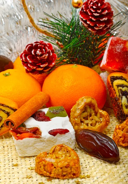Christmas tangerines, lokum, pinecone and brittle candies on chr — Stock Photo, Image