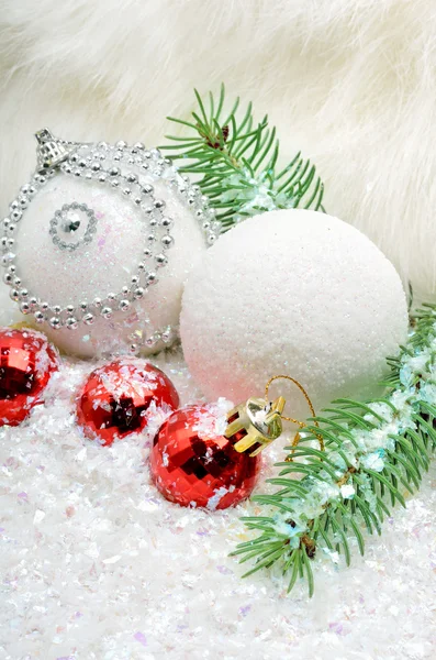 Jul bakgrund med snö, julgranskulor och pine kvistar — Stockfoto