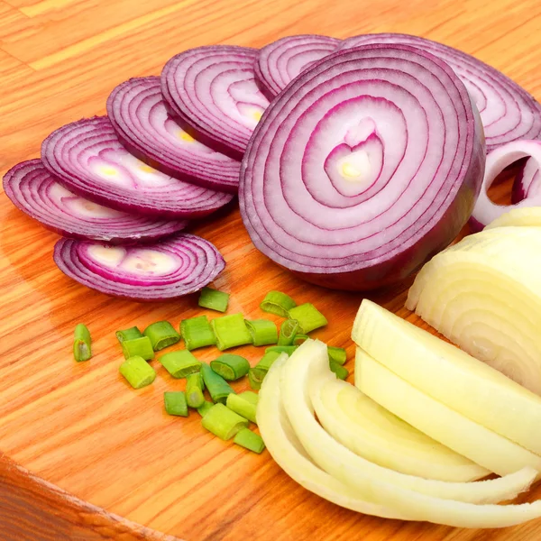 In Scheiben geschnittene rote und grüne Zwiebeln auf dem Schneidebrett — Stockfoto