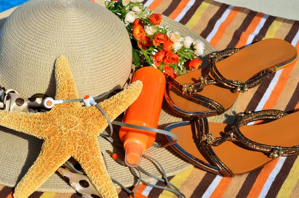 Beach hat, flip flops, head phones, sun spray. — Stock Photo, Image