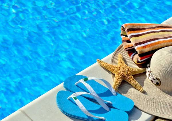 Woman beach hat, bright towel and blue flip-flops. — Stock Photo, Image