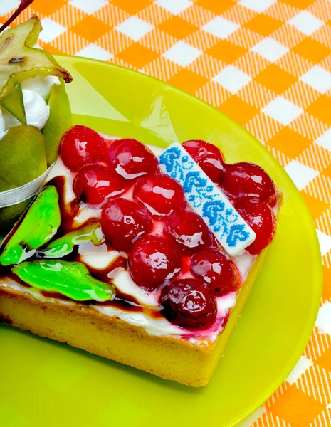 緑の皿の上の果実とケーキ. — ストック写真