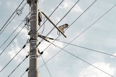Güvenlik kamerası ve bir sürü iletişim kablosu olan bir direk. Direkteki dağınık kablolar.