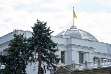 Ukrayna Parlamentosu binası. Ukrayna parlamentosu - ana yasama organı. Bayrak direğindeki Ukrayna bayrağı güzel bir gökyüzünde dalgalanıyor. Kyiv 'deki parlamento çatısı