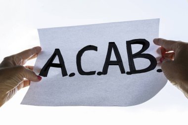 Bir protestocu ACAB harfleriyle pankart taşıyor. Protestoların sembolü polis şiddetine yol açıyor