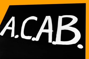 Beyaz A.C.A.B. 'li siyah poster. Turuncu arkaplanda yazı var. Siyahi karşıtı ırkçılığı ve polis şiddetini protesto etmek