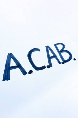 ACAB posteri. Beyaz bir posterde ACAB yazıları var. Ahlaksız polis konseptine ve dikey görüntüye karşı mitingler