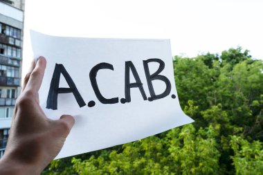 El A.C.A.B. 'yi tutuyor. Siyah Yaşamlar Önemlidir afişinde beyaz bir yazı var. Polisin keyfine karşı eylem