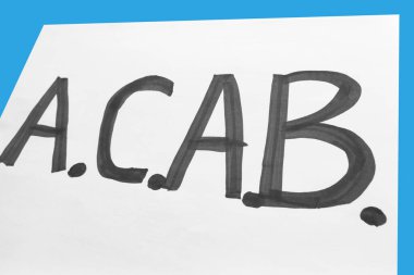 Siyah A.C.A.B. 'li beyaz poster. Mavi arkaplanda yazı var. Siyahi karşıtı ırkçılığı ve polis şiddetini protesto etmek