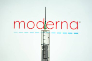Kyiv, Ukrayna 18 Nisan 2021: Arkaplanda Moderna Inc logosu olan bir tıp çalışanının eli. Koronavirüs ve Covid-19 salgınıyla savaşmak için aşı.
