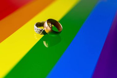 Renkli LGBT gökkuşağı arka planına karşı iki alyans. lgbt afişinin arka planında iki halka
