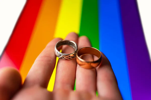 Gay Huwelijksaanzoek Hand Houdt Twee Trouwringen Lgbt Vlag Achtergrond Homohuwelijk — Stockfoto