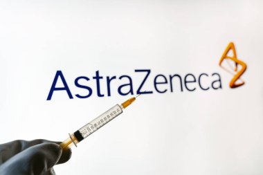 AstraZeneca, arka planda bulanık AstraZeneca şirketinin logosuna karşı yapılan şırıngada Covid 19 aşısını araştırıyor. Kyiv, Ukrayna 18 Nisan 2021