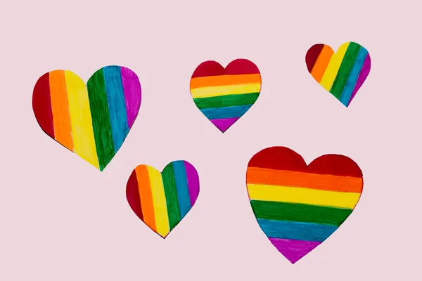 diversity of the LGBTQ people concept. various hearts painted in rainbow colors on a pink background as a symbol of LGBT people. hand-made paper hearts painted in rainbow colors. Rainbow heart. Love, human rights