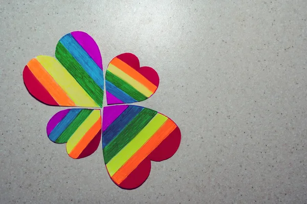 several rainbow hearts are placed in the shape of a flower, flat-lay view. LGBTQ rainbow heart concept for lesbian, gay, bisexual, transgender, and queer people