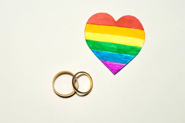 虹色の紙の心を持つ黄金のリングのカップル Lgbtq 結婚の概念 ゲイまたはレズビアンのカップルの結婚の概念 — ストック写真