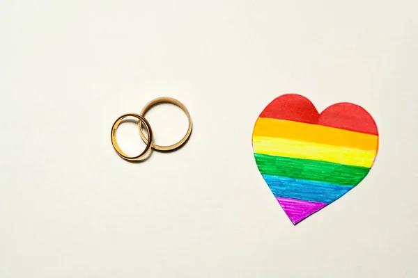 Kilka Złotych Pierścieni Papierowym Sercem Tęczowych Kolorach Koncepcja Małżeństwa Lgbtq — Zdjęcie stockowe