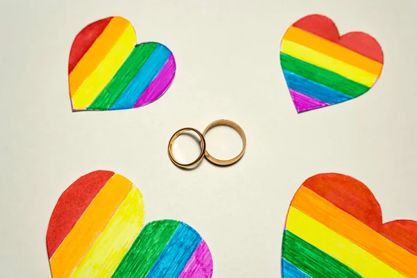 Twee Gouden Ringen Tussen Papieren Uitgesneden Harten Gekleurd Als Lgbt — Stockfoto