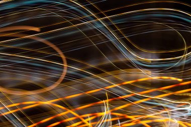 yellow light lines on dark background. the light trails on the street captured with a long exposure shot