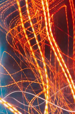 red light lines painting, long exposure photography, abstract waves against a dark background. Long exposure photo taken on a road