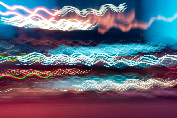 Bright swirly lines on dark background. the light trails on the street. blue and gold wavy light lines - blurred abstract background
