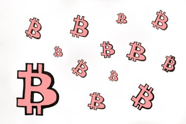 Pembe elin fotoğrafı beyaz kağıda farklı boyutlarda Bitcoin simgeleri çizdi. Bitcoin kripto para piyasası. E-para birimi kavramına yatırımlar.