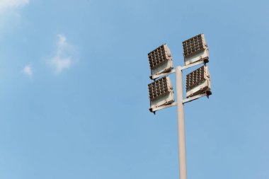 Mavi gökyüzü arka planında dört lamba olan bir anket. Sokakları aydınlatmak için teknoloji 