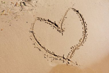 Kalp deniz kıyısında çizilmiş. Kalbim kumsalda. Sonsuz aşkın sembolü olarak kalp.